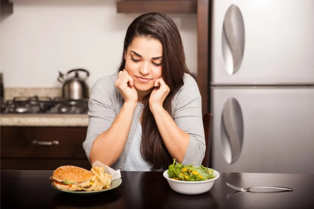 Girl with hunger and craving for burger and salad. 