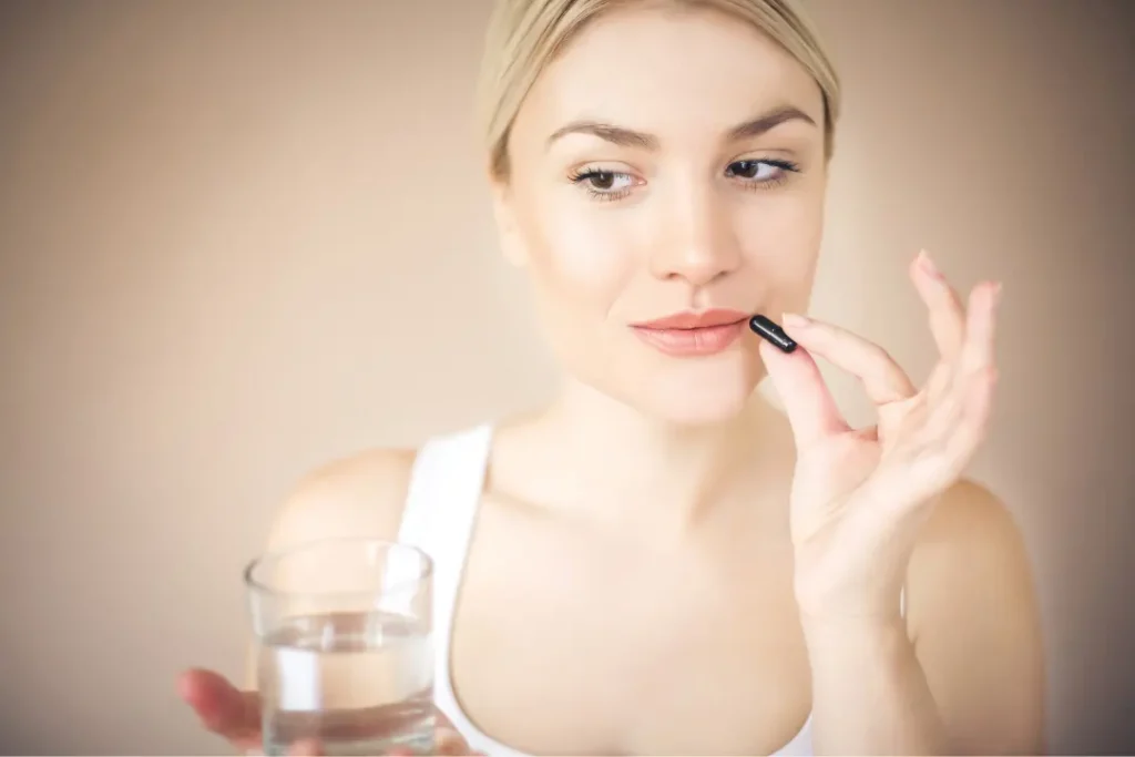 Woman taking Zeolite crystals supplements for body detoxification. 