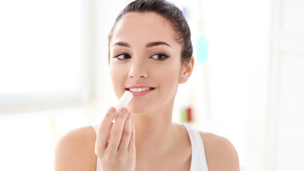 Lady is applying lip balms. 